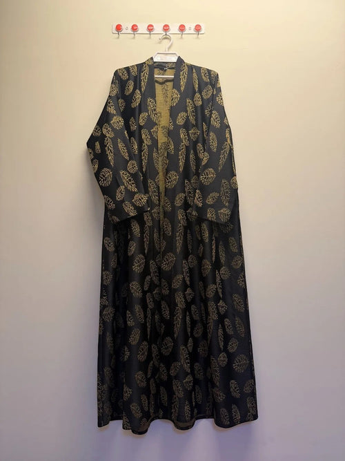 A&M FANCY STORE black abaya with gold leaf print, open-front, flowing fabric, elegant kimono robe style.