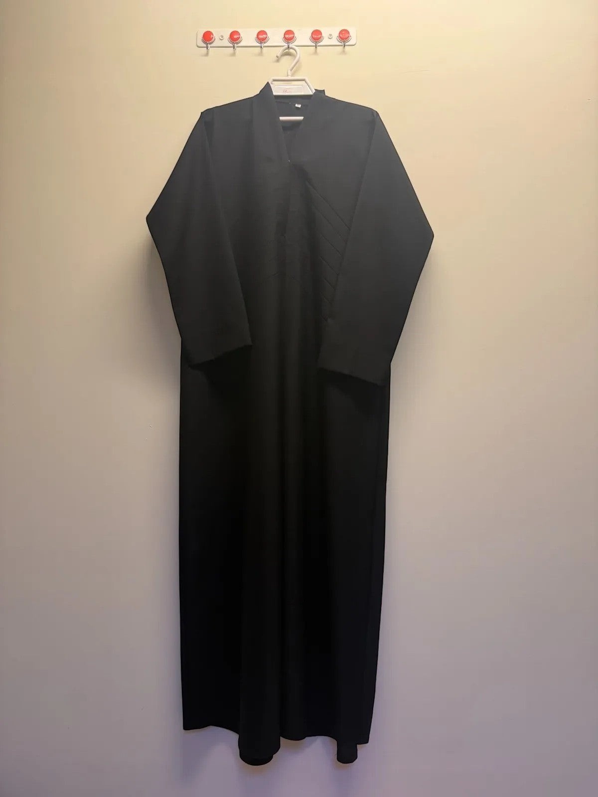 A&M Fancy Store black long sleeve maxi abaya dress with V-neckline and pleated bodice detail. Flowing fabric.